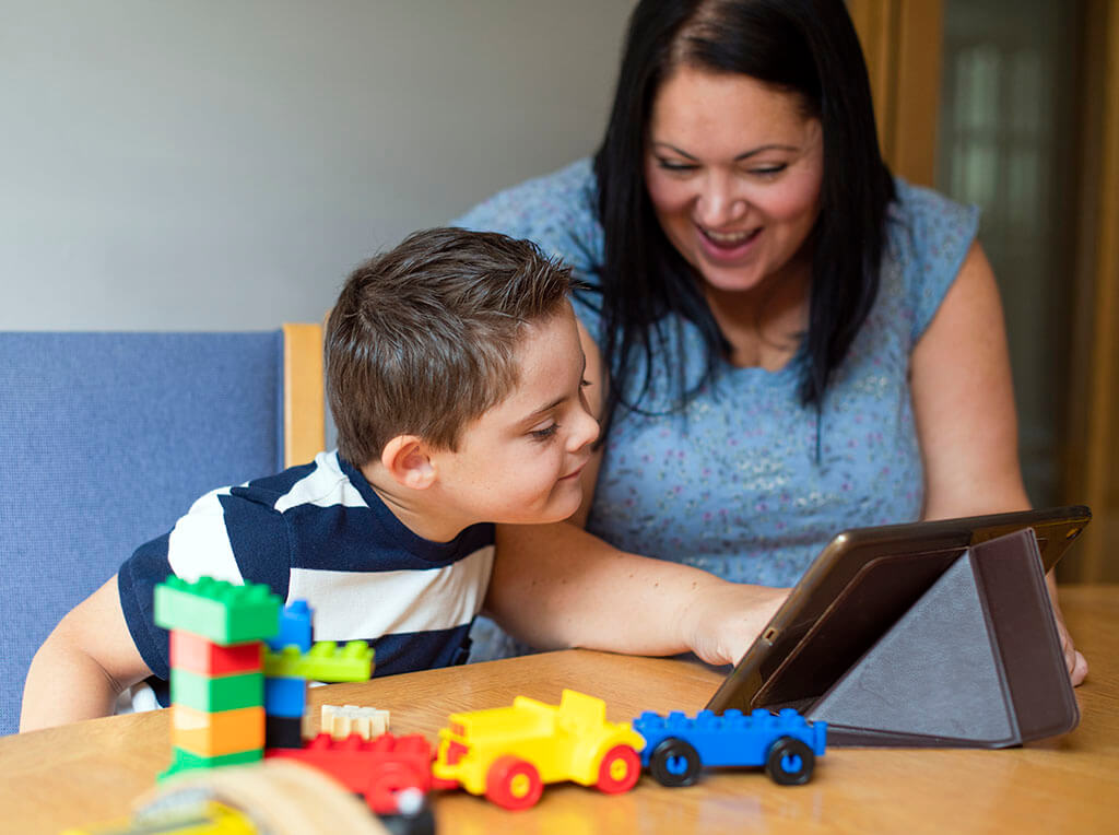 Mother teaching son from a tablet