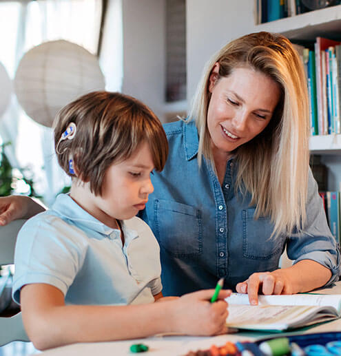 Mother helping her son to finish homework.