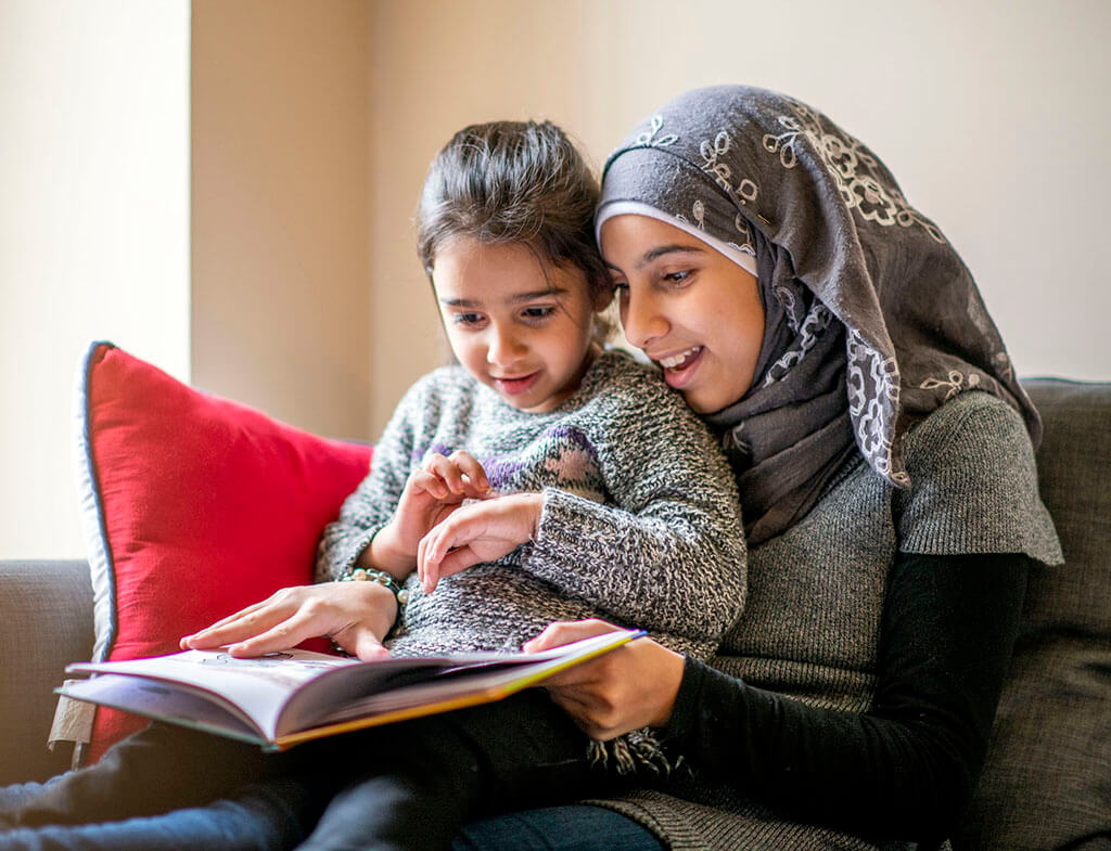 Big sister reads stories to her little sister