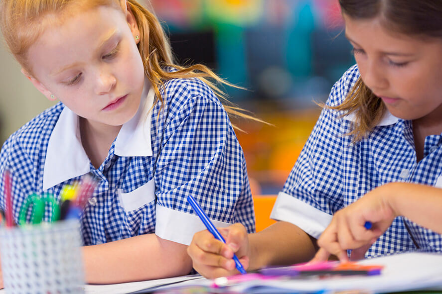 Two young female students working in the classroom.