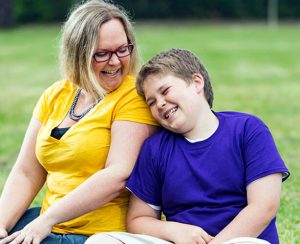 Mother and son laughing in the park.