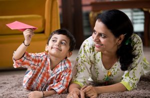 Mother and son playing with paper airplane.