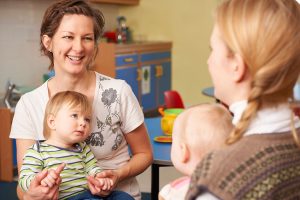 Two mums with young children having a chat at playgroup.