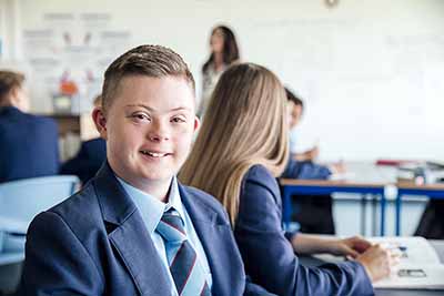 A teenage boy with Down syndrome in class.