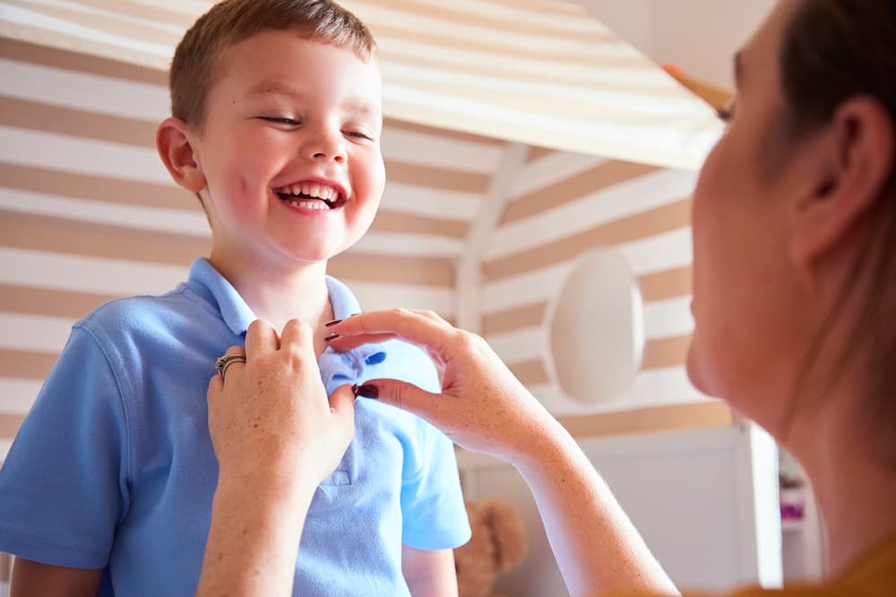 A primary school boy laughing with his mother.